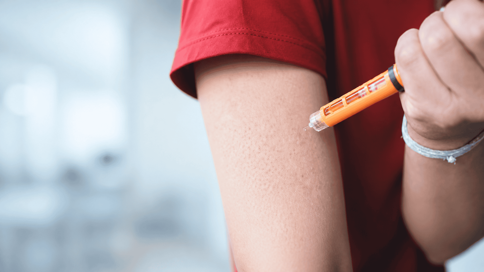 Combination products Generic auto-injector positioned beside a patient’s upper arm, illustrating a drug-device combination product.